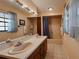 Bright bathroom featuring a double sink vanity, tiled floor, and a combined tub and shower with neutral accents at 5004 Grainary Ave, Tampa, FL 33624