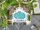 Aerial view of a beautifully designed pool with lounge chairs surrounded by lush landscaping and apartment buildings at 5125 Palm Springs Blvd # 3108, Tampa, FL 33647
