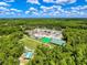 Aerial view of commercial building surrounded by lush green forest and landscaping under a sunny blue sky at 5125 Palm Springs Blvd # 3108, Tampa, FL 33647