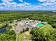Aerial view of a commercial complex including a pond, fields and lots of parking surrounded by lush forest at 5125 Palm Springs Blvd # 3108, Tampa, FL 33647