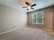 Well-lit bedroom featuring carpeted floors, a ceiling fan, and a large window with blinds at 5125 Palm Springs Blvd # 3108, Tampa, FL 33647