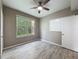Cozy bedroom with wood-look floors, a ceiling fan, and a window offering natural light and scenic views at 5125 Palm Springs Blvd # 3108, Tampa, FL 33647