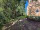 Backyard with view of building's exterior and screened patios, surrounded by trees at 5125 Palm Springs Blvd # 3108, Tampa, FL 33647