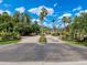 Community entrance with palm trees, brick-paved roads and manicured landscaping under a bright blue cloudy sky at 5125 Palm Springs Blvd # 3108, Tampa, FL 33647