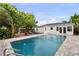 Backyard oasis featuring a beautiful pool with brick pavers, lush landscaping, and lounge chairs for relaxing at 549 39Th Ne Ave, St Petersburg, FL 33703