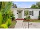 Inviting front porch with a brick landing, updated door and a lush, tropical landscaped yard at 549 39Th Ne Ave, St Petersburg, FL 33703