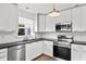 Modern kitchen featuring stainless steel appliances, white cabinets, and black countertops at 549 39Th Ne Ave, St Petersburg, FL 33703