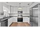 Modern kitchen featuring stainless steel appliances, white cabinets, and black countertops at 549 39Th Ne Ave, St Petersburg, FL 33703