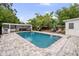 Backyard pool area boasts stone pavers, covered seating, and ample greenery for a private, relaxing outdoor experience at 549 39Th Ne Ave, St Petersburg, FL 33703