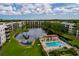Stunning aerial view of community featuring a pool, lake, clubhouse, and lush landscaping at 6190 80Th N St # 310, St Petersburg, FL 33709