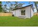Home exterior showcasing a well-maintained lawn, privacy fence, and a contemporary design at 7509 E 26Th Ave, Tampa, FL 33619