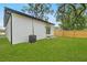 Home exterior showcasing a well-maintained lawn, privacy fence, and a contemporary design at 7509 E 26Th Ave, Tampa, FL 33619