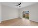 Bright bedroom features wood-look flooring, contemporary ceiling fan, and sliding glass doors to the yard at 7509 E 26Th Ave, Tampa, FL 33619