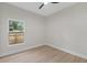 Bedroom features wood-look flooring, contemporary ceiling fan, and large windows at 7509 E 26Th Ave, Tampa, FL 33619