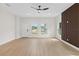 Spacious living area with light wood floors, large windows and modern ceiling fan at 7509 E 26Th Ave, Tampa, FL 33619