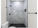 Elegant bathroom featuring a stand-up shower with tiled walls and dark pebble floor at 7509 E 26Th Ave, Tampa, FL 33619
