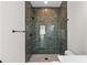 Beautiful tiled walk-in shower features a river rock floor, niche, rainfall shower head, and modern finishes at 7509 E 26Th Ave, Tampa, FL 33619