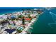 Beachfront neighborhood aerial showing homes with private beaches, boat docks, and swimming pools on a sunny day at 7777 Bayshore Dr, Treasure Island, FL 33706
