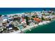 Coastal neighborhood aerial showing homes with private beaches, boat docks, and swimming pools on a sunny day at 7777 Bayshore Dr, Treasure Island, FL 33706