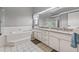 Bright bathroom with dual sinks, a soaking tub, and a glass-enclosed shower at 8441 Danbury Ln, Hudson, FL 34667
