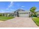 Attractive one-story home boasts a vibrant green lawn, brick driveway, and a spacious two-car garage at 8441 Danbury Ln, Hudson, FL 34667