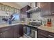 Close up of updated kitchen with stainless steel oven and range hood against a decorative backsplash at 8441 Danbury Ln, Hudson, FL 34667
