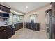 Kitchen area featuring sleek, dark wood cabinets, stainless steel appliances, and a bright window bay at 8441 Danbury Ln, Hudson, FL 34667