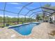 Backyard features screened in pool with pavers, landscaping, and fenced perimeter at 8441 Danbury Ln, Hudson, FL 34667