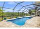 Screened-in pool with a hot tub and lush landscaping at 8441 Danbury Ln, Hudson, FL 34667