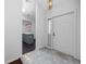 Bright entryway featuring neutral tile floors, white walls, and a view into the kitchen with a gray island at 944 San Carlos Ne Ct, St Petersburg, FL 33702