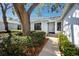 Inviting front entrance with lush greenery, a large shade tree, and a well-lit walkway to the front door at 944 San Carlos Ne Ct, St Petersburg, FL 33702