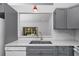 A well-lit kitchen showcasing stainless steel appliances, grey cabinets, and a double basin sink at 944 San Carlos Ne Ct, St Petersburg, FL 33702
