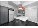 Modern kitchen featuring grey cabinets, an island with a white countertop, and stylish red pendant lighting at 944 San Carlos Ne Ct, St Petersburg, FL 33702