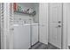 Functional laundry area with white washer, dryer, shelving, and door at 944 San Carlos Ne Ct, St Petersburg, FL 33702