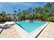 Community pool and adjacent structure surrounded by tropical landscaping at 944 San Carlos Ne Ct, St Petersburg, FL 33702