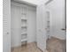 View of Walk-in closet with custom shelving and tile flooring at 944 San Carlos Ne Ct, St Petersburg, FL 33702