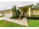 Charming home featuring a well-manicured lawn, mature palm trees and a two-car garage at 1051 Glynwood Pl, Dunedin, FL 34698