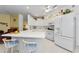 Bright kitchen featuring white cabinets, appliances, and a counter with bar stool seating at 1051 Glynwood Pl, Dunedin, FL 34698