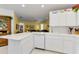 Open kitchen with ample counter space, white cabinets, and a view into the living area at 1051 Glynwood Pl, Dunedin, FL 34698