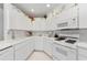 Well-lit kitchen featuring white appliances, plenty of counter space, and ample cabinet storage at 1051 Glynwood Pl, Dunedin, FL 34698
