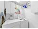 Clean laundry room with a window and equipped with washer, dryer and storage cabinets at 1051 Glynwood Pl, Dunedin, FL 34698