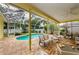 Screened patio with brick pavers, a ceiling fan, outdoor furniture, and a view of the pool at 1051 Glynwood Pl, Dunedin, FL 34698