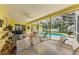 Spacious screened lanai with brick pavers and ample seating overlooks a refreshing pool area at 1051 Glynwood Pl, Dunedin, FL 34698