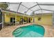 Backyard featuring a screened in pool, brick patio, and access to seating and entertaining areas at 1051 Glynwood Pl, Dunedin, FL 34698