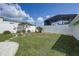 Large backyard with a firepit, wooden benches, white fencing, and meticulously maintained green lawn at 106 W Minnehaha St, Tampa, FL 33604