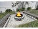 Close up of a beautiful backyard firepit surrounded by seating and white gravel at 106 W Minnehaha St, Tampa, FL 33604