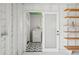 Interior of garage leading to laundry room with white walls and light colored wooden shelves at 106 W Minnehaha St, Tampa, FL 33604