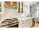 A kitchen featuring a stainless steel stove and hood, with glass-front cabinets at 106 W Minnehaha St, Tampa, FL 33604