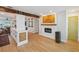 Open-concept living room featuring wood beam, decorative fireplace, and hardwood flooring at 106 W Minnehaha St, Tampa, FL 33604