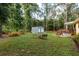Backyard showing fire pit with seating, wooden deck with hot tub, and storage shed at 10804 Bounty St, New Port Richey, FL 34654